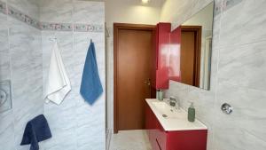 bagno con lavandino e armadietto rosso di Mazzini Bilo Roseto Vacanza a Roseto degli Abruzzi