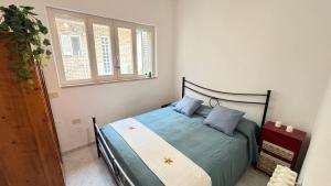 una camera da letto con un letto con cuscini blu e una finestra di Mazzini Bilo Roseto Vacanza a Roseto degli Abruzzi