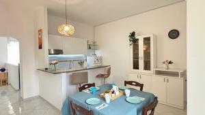 una cucina e una sala da pranzo con un tavolo blu di Mazzini Bilo Roseto Vacanza a Roseto degli Abruzzi Altre 6 foto