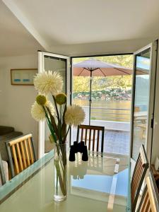 un vaso di fiori seduto su un tavolo di vetro di House with big terrace and beautiful sea view a Kotor (Cattaro)