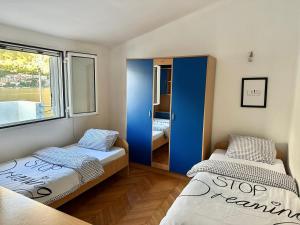 Cette petite chambre comprend 2 lits et une fenêtre. dans l'établissement House with big terrace and beautiful sea view, à Kotor