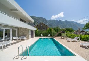 a villa with a swimming pool with mountains in the background at Villa Tor in Gornji Orahovac