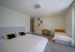 a white bedroom with two beds and a desk at Villa Tor in Gornji Orahovac +37 photos