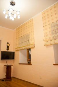 a room with a tv and a wall with curtains at Bazar Apartment in Chişinău