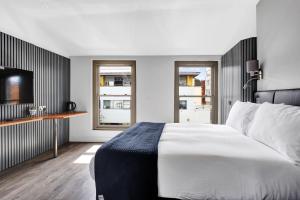 a bedroom with a large white bed and a desk at Skyline Studios in London
