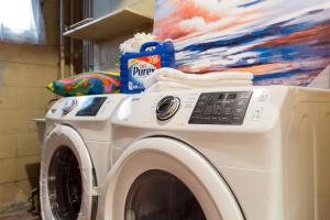uma máquina de lavar roupa num quarto com uma pintura em Vihome3001C1-3-Bedroom house facing park and school em Toronto
