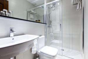Un baño blanco con lavabo y ducha. en Hostal Castilla I Atocha, en Madrid