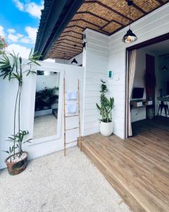 Un porche con dos plantas y un espejo. en Negrita House Canggu Apartment, en Canggu