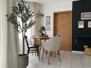 コブレンツにあるModerne Wohnung mit Terrasse & Parkplatz; Nähe BWZK & Amazonの食卓と鉢植えの木があるダイニングルーム