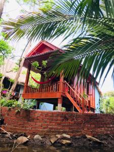 貢布的住宿－Retro Kampot Guesthouse，砖墙顶部有甲板的房子