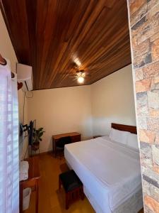 sypialnia z łóżkiem i kamienną ścianą w obiekcie Hotel Mirna & OCT w mieście Granada