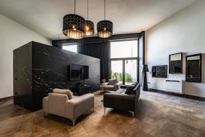 a living room with two chairs and a tv at Neko Boutique Hotel in Cagliari