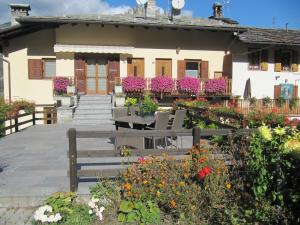 アオスタにあるMaison La Tourのベンチと花の家