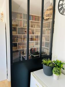 ein schwarzer Schrank voller Bücher auf einem Tresen in der Unterkunft L Abri Côtier -Studio au calme 2 pas de la plage et du centre de ville in Blonville-sur-Mer