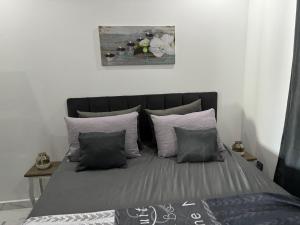 - un lit avec des draps gris et des oreillers dans l'établissement Maha Beach Cabo Negro Duplex, à Cabo Negro