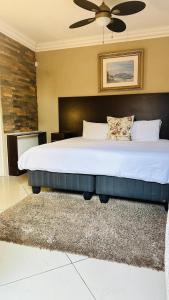 sypialnia z dużym łóżkiem i wentylatorem sufitowym w obiekcie Sunrise Boutique Hotel w mieście Witbank