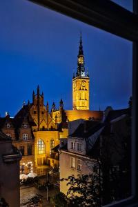 a building with a clock tower at night at Baltic Gdansk OLD TOWN in Gdańsk