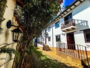 a building with a tree next to a street at Casa Colonial en el corazón de Villa de Leyva Casa serena in Villa de Leyva