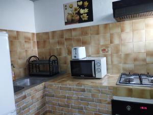 a kitchen counter with a microwave and a stove at Beauty Paradies in Goyave