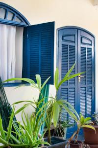 a house with blue shutters and plants at Casa Surya Paraty in Paraty