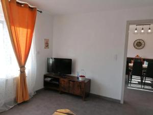 a living room with a flat screen tv and a table at Maison conviviale à Farschviller in Farschviller
