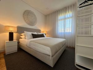 a bedroom with a white bed and a window at Achada Sol in Funchal