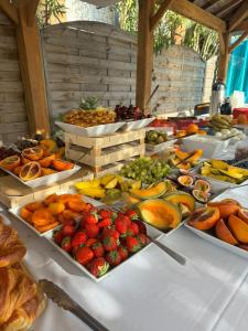 um buffet de frutas e vegetais numa mesa em Le Jardin de Babylone "réservé aux couples" em Cap d'Agde