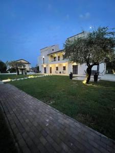 a large white building with a tree in the yard at Villa Rodelia in Roda