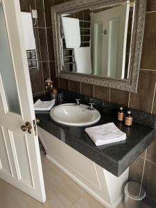 Towers Hotel Glenbeigh في غلينبييْ: حمام مع حوض ومرآة