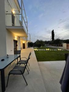 un patio con mesa, sillas y césped en Villa Rodelia en Roda
