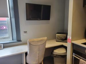 um quarto com uma secretária com uma cadeira e uma televisão em Tren-D Luxe Studio Apartment Room 3 - Contractors, Relocators, Profesionals, NHS Staff Welcome em Sunderland