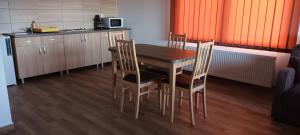 eine Küche mit einem Tisch und Stühlen im Zimmer in der Unterkunft Betula Apartman in Sovata