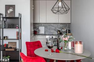 a kitchen with a table and red chairs at Home sweet home, cozy apartments, free underground parking, long stays welcome in Vilnius +15 photos