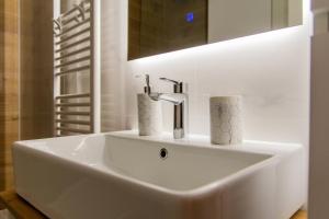 a white sink in a bathroom with a mirror at Flexible SelfCheckIns 81 - Zagreb - Arena - Garage - Loggia in Zagreb +22 photos