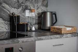 a counter top with a coffee pot and a basket on it at Home sweet home, cozy apartments, free underground parking, long stays welcome in Vilnius