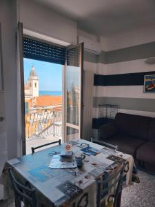 a living room with a table and a view of the ocean at Residence Corallo in Alassio