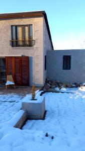 une maison avec de la neige devant elle dans l'établissement Hidden Twins Cabañas de montaña Cacheuta, à Cacheuta