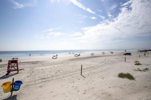 una spiaggia con un gruppo di persone sulla spiaggia di SeaBliss, oceanfront 1st floor cozy condo a Daytona Beach