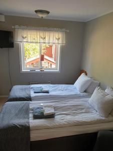 a bedroom with a large white bed with a window at Turistgården Töcksfors in Töcksfors