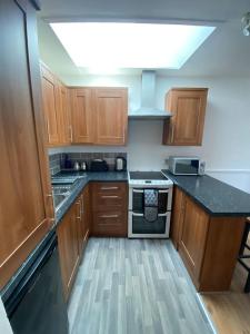 a kitchen with wooden cabinets and a stove top oven at Cute 1 bed flat in Southwold in Southwold +5 photos