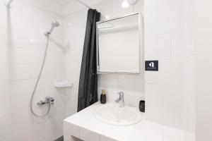 a white bathroom with a sink and a shower at Urban Harmony Apartment in Thessaloniki +37 photos