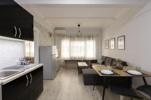 a kitchen and living room with a couch and a table at Urban Harmony Apartment in Thessaloniki