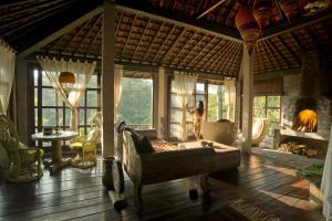 sala de estar con sofá y chimenea en Villa Kalisat Resort, en Ubud