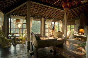 a living room with a couch and a fireplace at Villa Kalisat Resort in Ubud