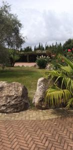 a garden with two large rocks and a field of grass at Villa Sorrentina in Alghero