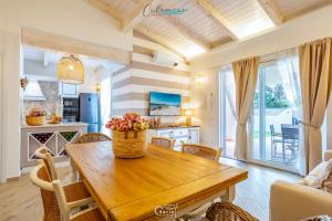 a kitchen and dining room with a wooden table and chairs at Calamore in Valledoria