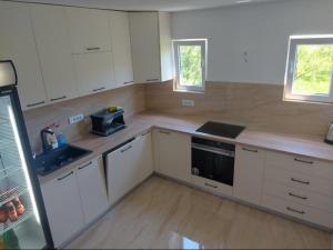 a kitchen with white cabinets and a counter top at Rooms Lida & Friendly home in Plav