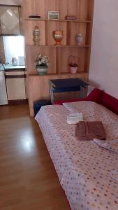 a room with a bed with a table and a kitchen at Aleksinac Centar-Vojislav Eror in Aleksinac
