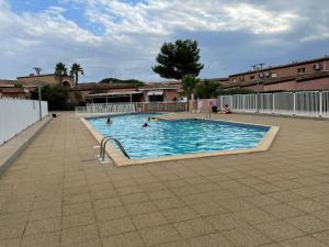 a large swimming pool with people in the water at Villa 2 étoiles proche plage et commerces in Saint-Cyprien