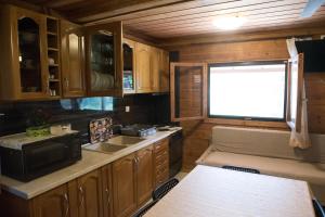 a kitchen with wooden cabinets and a sink and a window at Garden Villa in Stavros +27 photos